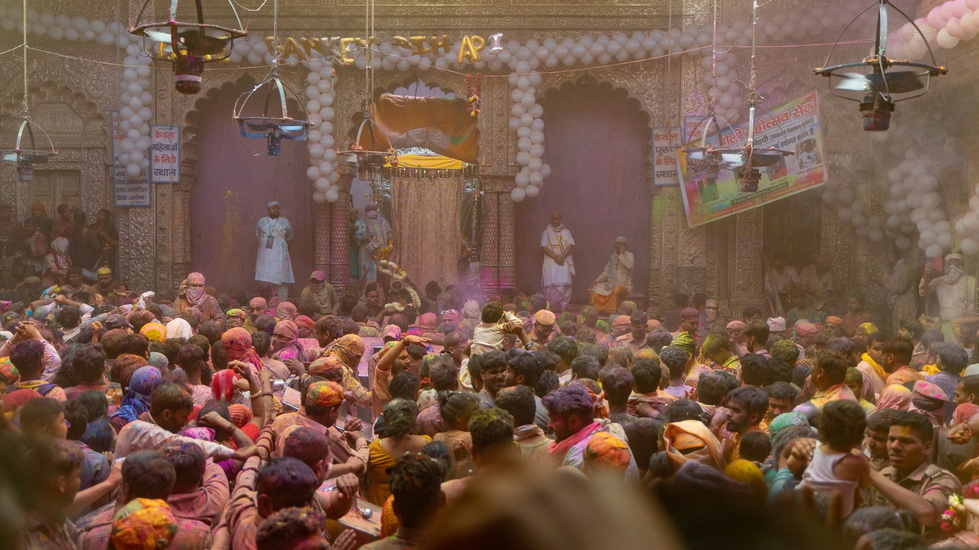 People celebrating Holi festival at Banke Bihari temple in Vrindavan, India